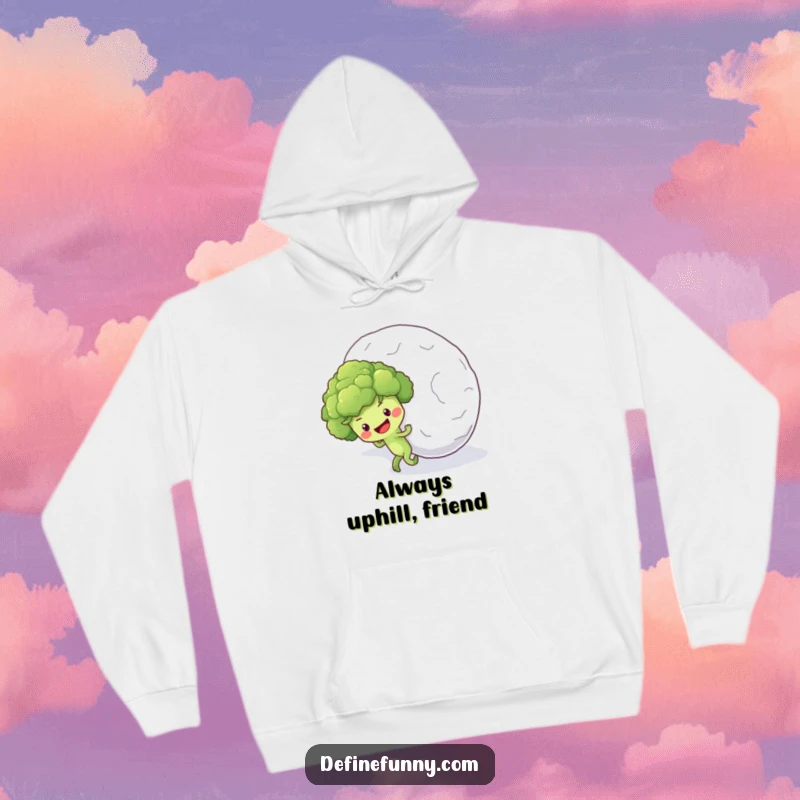 Funny hoodie featuring a determined broccoli floret character struggling to push a huge snowball up a snowy incline.