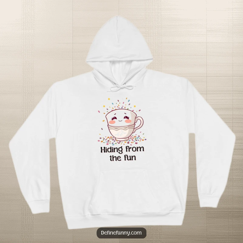 Funny hoodie depicting a shy teacup character with rosy cheeks hiding from falling confetti, a warm and humorous introvert gift.