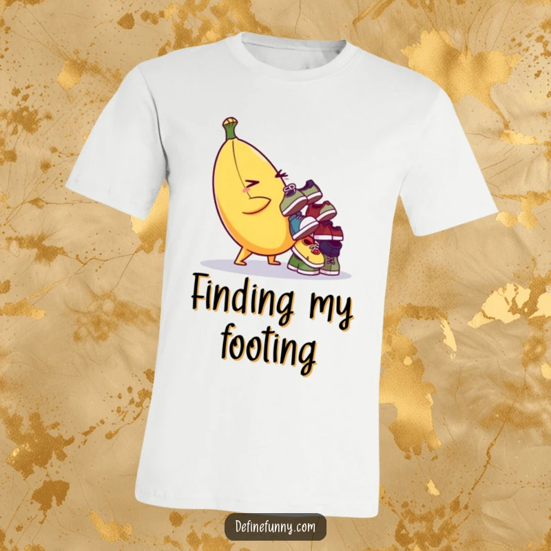 Funny T-shirt of a winking banana character precariously balancing a stack of tiny, odd shoes. Humorous and whimsical.